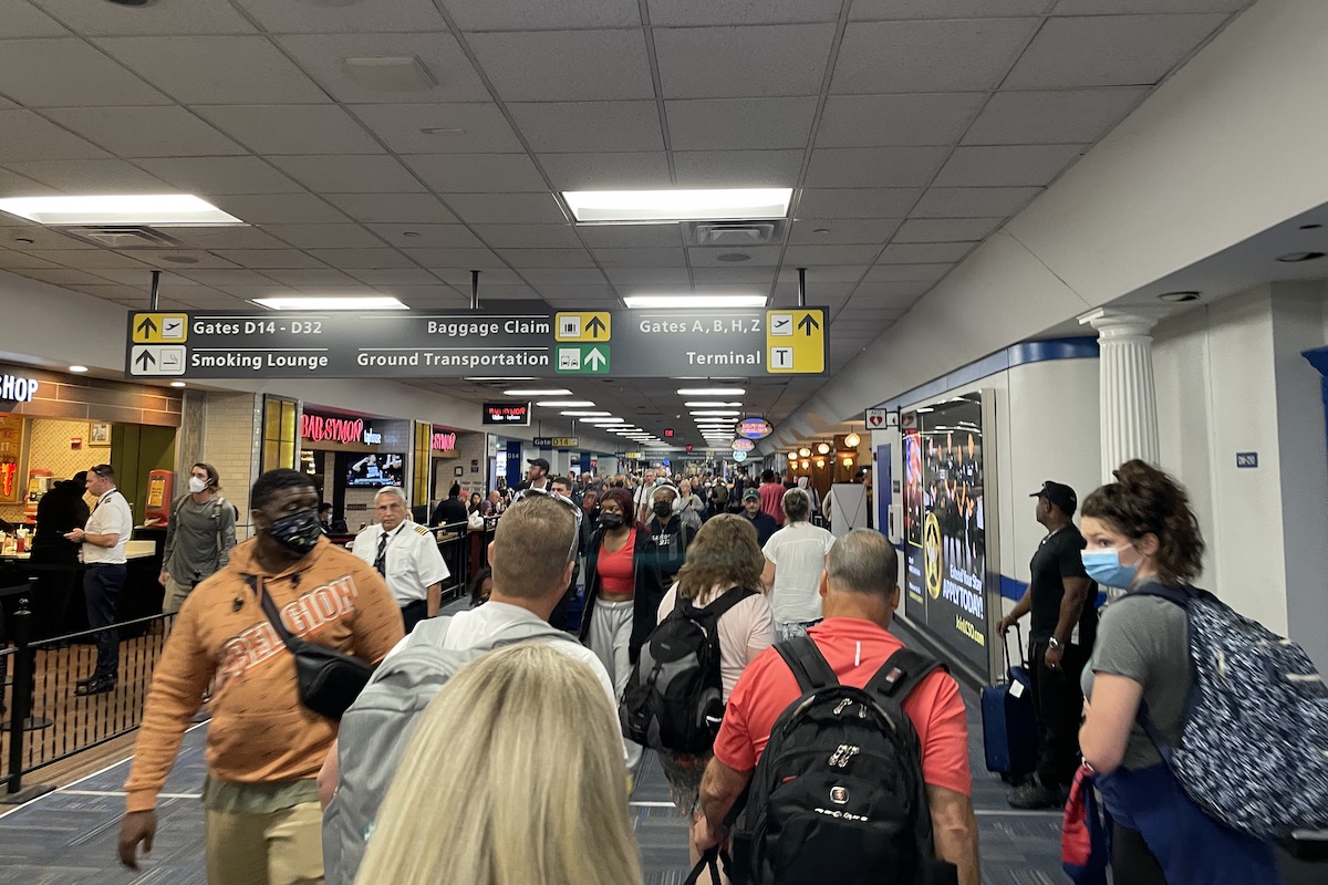 Travelers crowd a concourse at Washington Dulles airport.